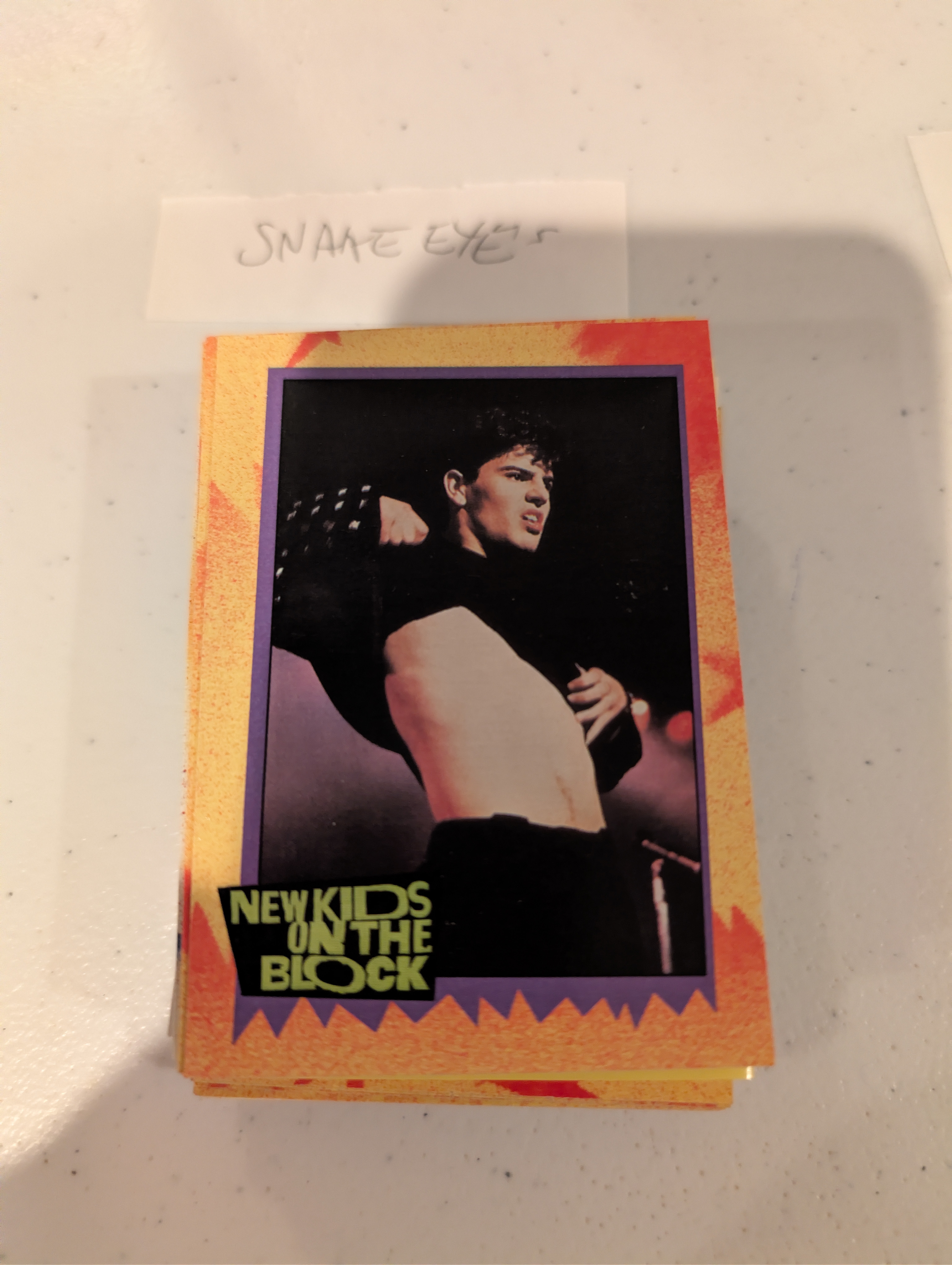 Jordan Knight from New Kids on the Block pulling up his shirt on stage, a humorous nod to 'grail' cards of the past.